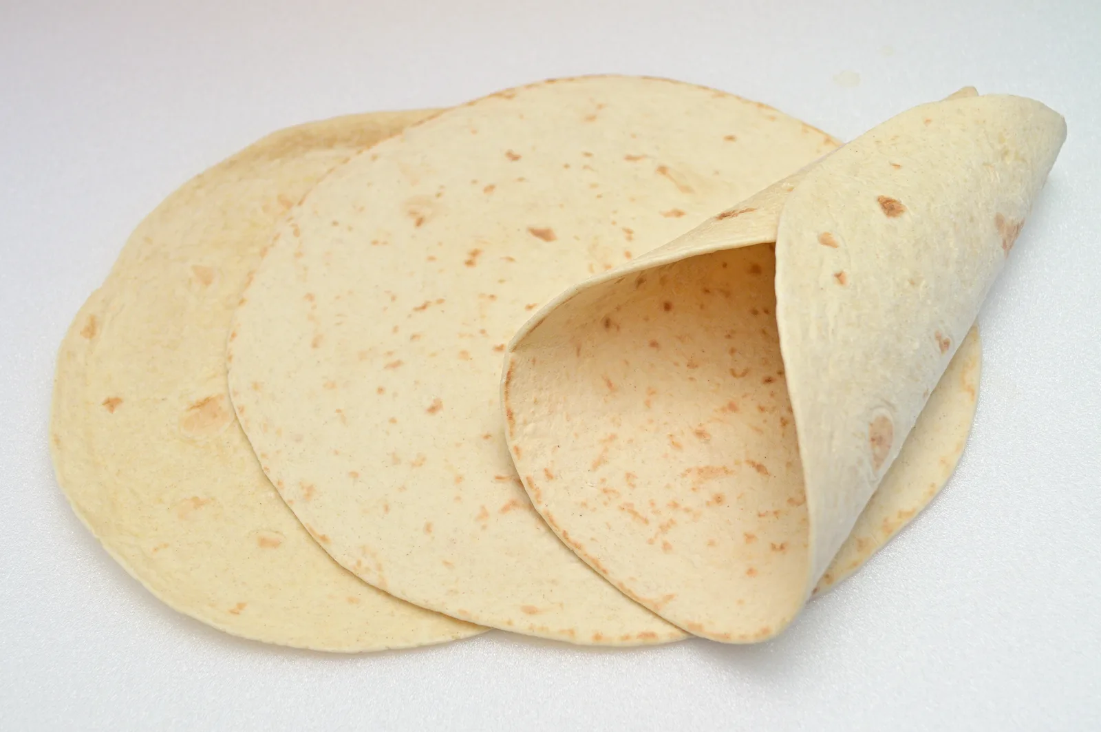 Three flour tortillas, one folded into a cone